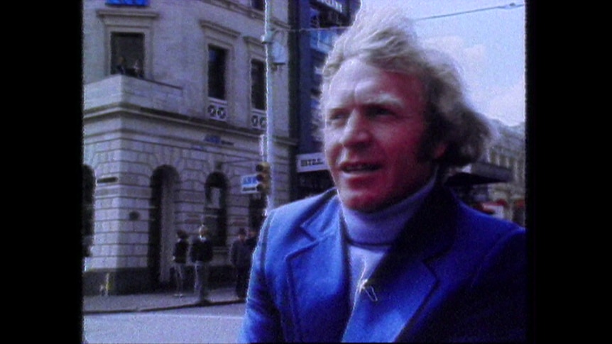 Barry Cable sits in a car wearing blue