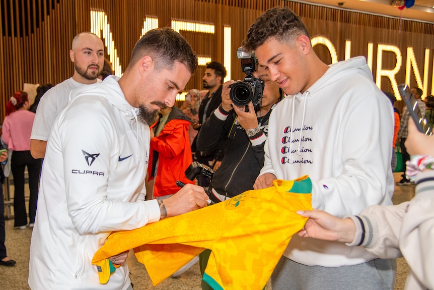 Maclaren signs a fans Socceroos jersey. 