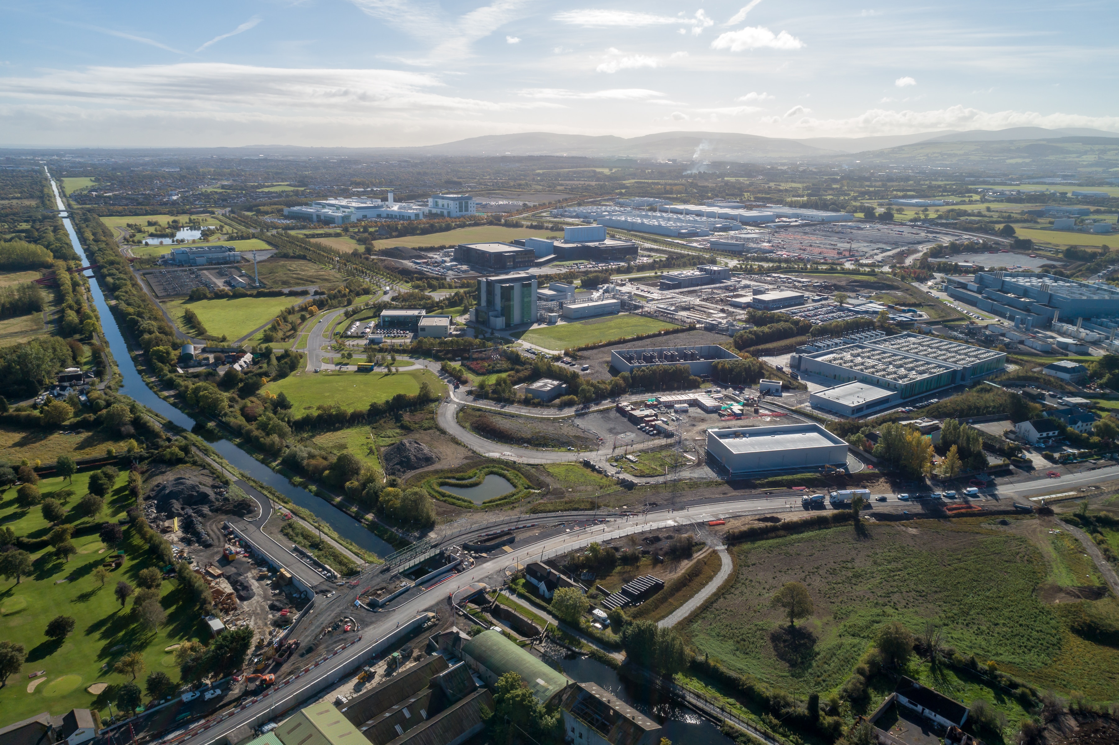 Aerial view of a sprawling business park with a river in view and residential areas. 