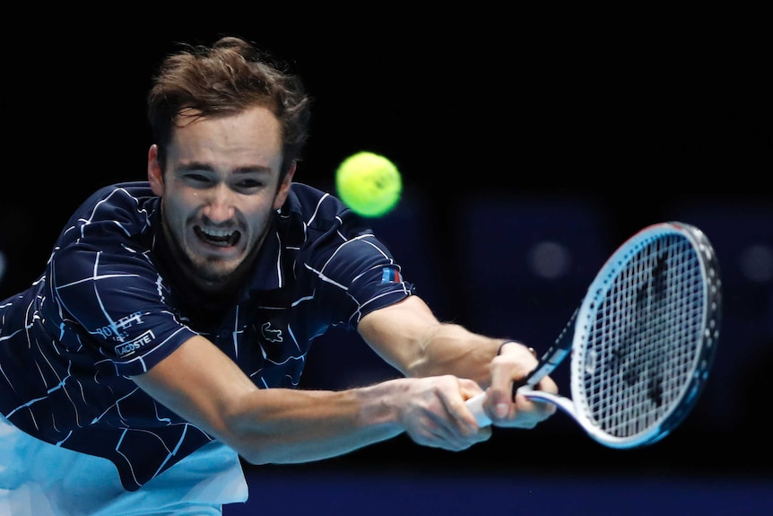 Daniil Medvedev stretches and grimaces for a shot