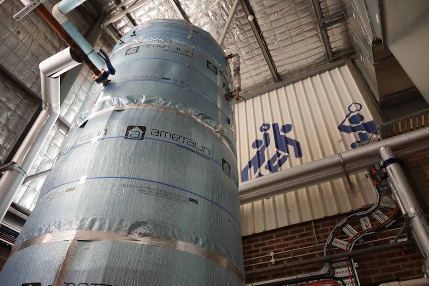 A large tank wrapped in thermal padding inside an industrial building structure