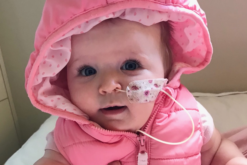 Baby in pink hood and with nasogastric tube