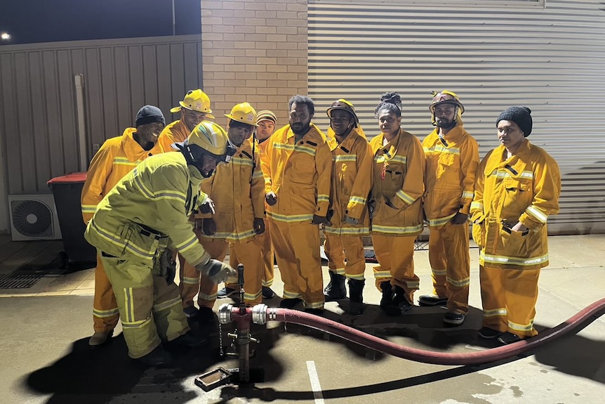 A group of people in CFA uniforms around a fire hydrant.
