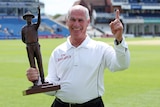 Rudi Koertzen holding a trophy pointing a finger up