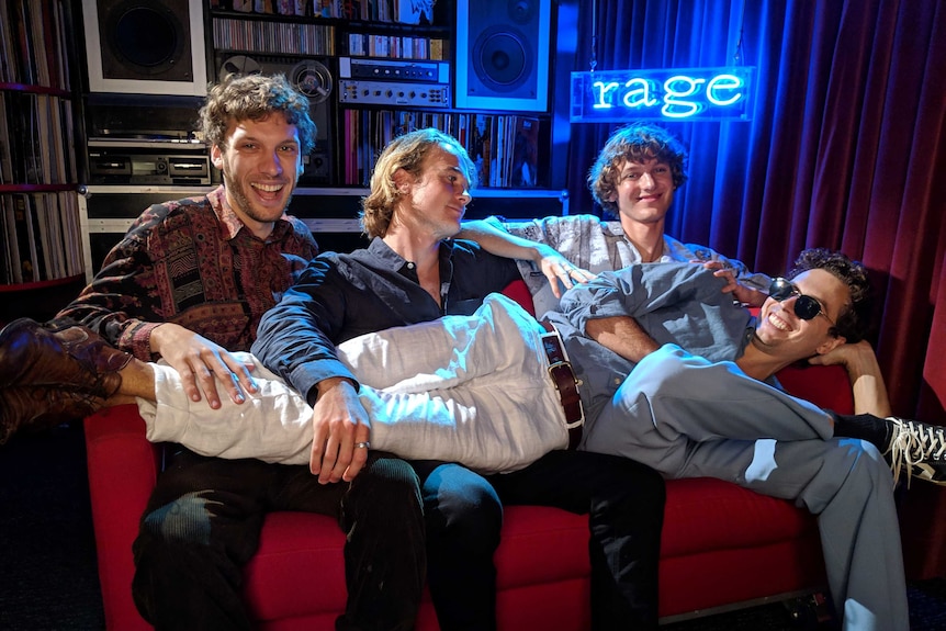 Band members from Tora sitting on the couch with one of them lying across the other members