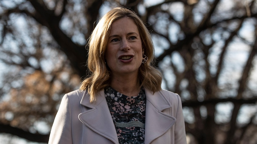 Rebecca White speaks outside, there is a tree in the background