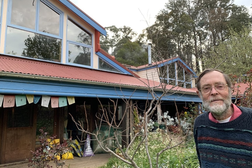 Fred Koch standing in front of home with abundant garden