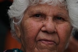An up close photo of an older woman looking at the camera.