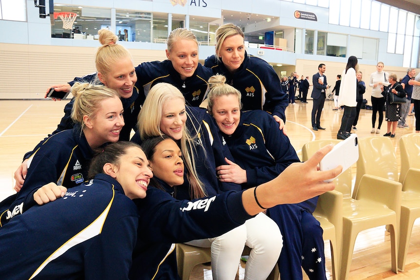 Lauren Jackson poses for a photo with the Australian team after announcing her retirement from basketball.