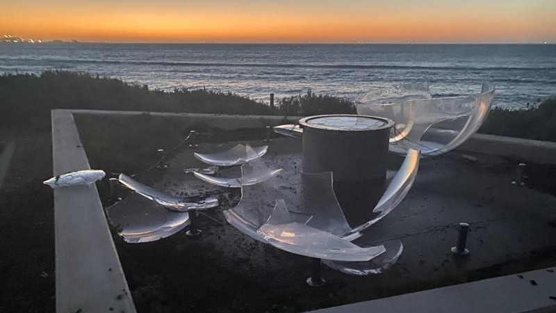 photo of broken pieces of an acrylic sphere laying on a concrete platform with the evening sky and ocean in the background