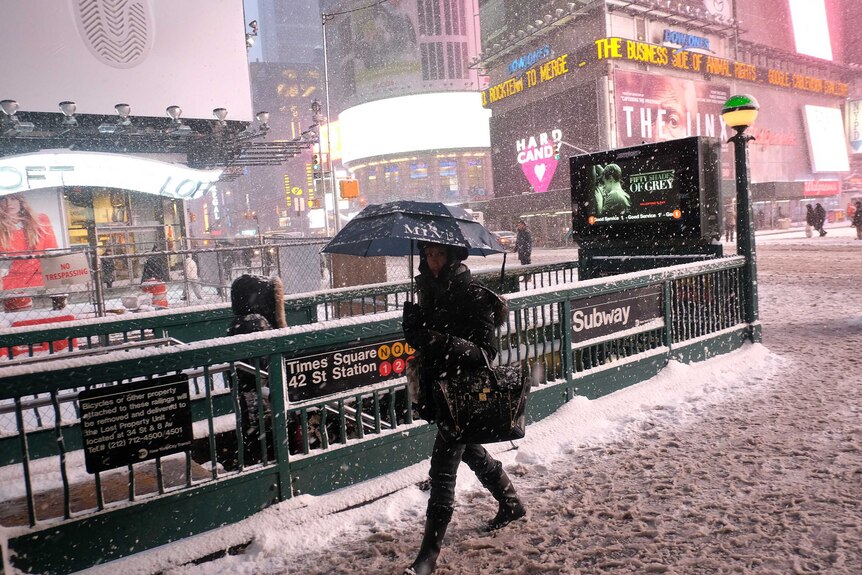A woman heads to a subway station in New York's Times Square