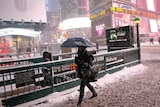 A woman heads to a subway station in New York's Times Square