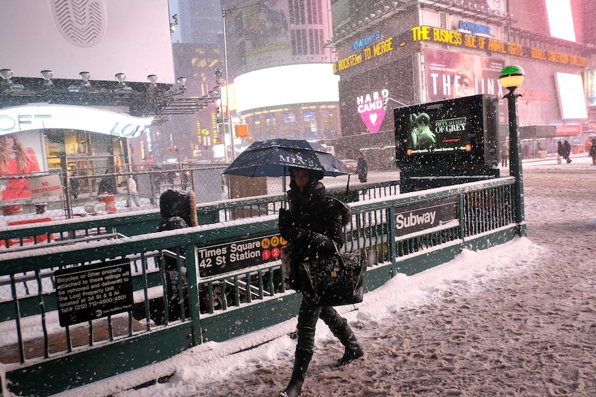 A woman heads to a subway station in New York's Times Square