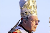 Cardinal George Pell, pictured in 2008, wears a headdress and holds a staff.