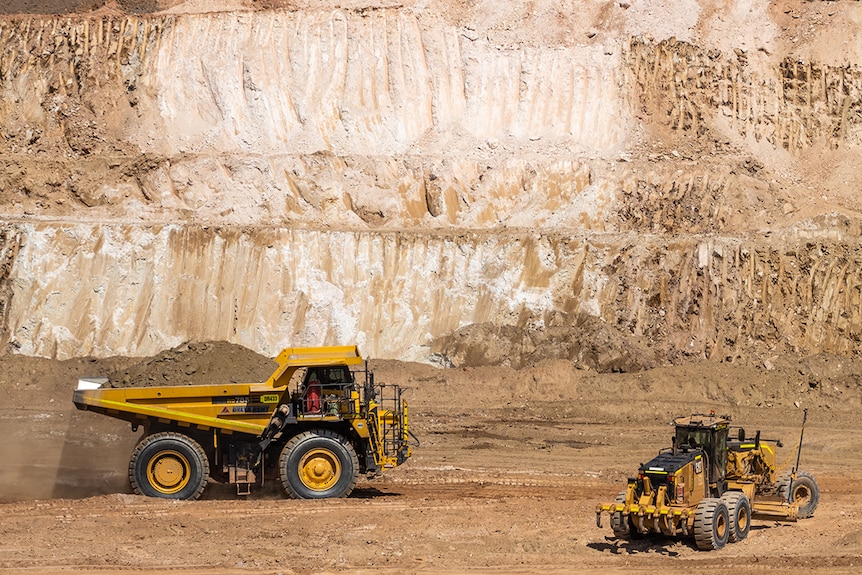 a mine site with a big truck and white rock