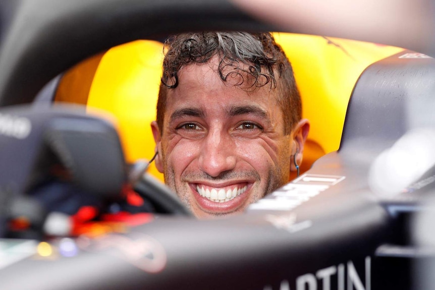 Daniel Ricciardo smiles from the cockpit of his car.