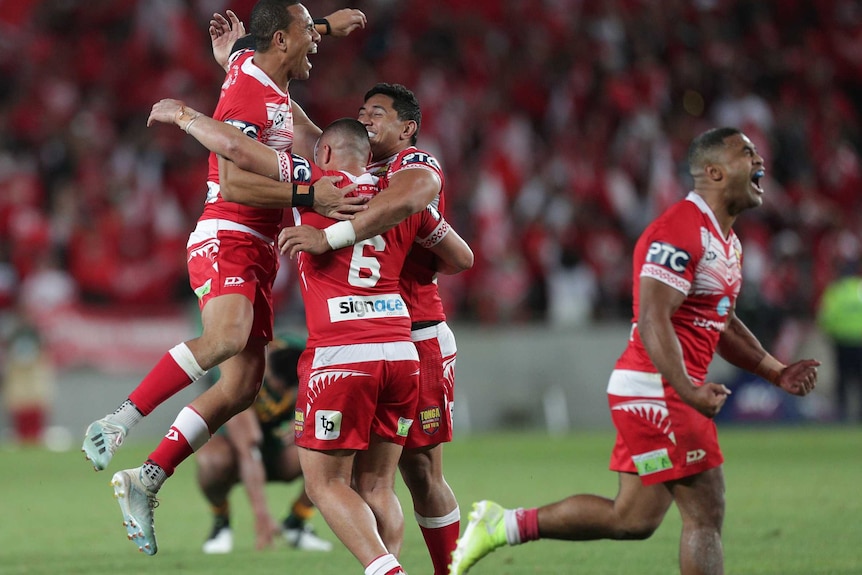 Tonga players embrace after beating Australian in a rugby league Test at Eden Park.