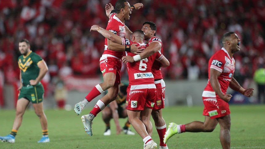 Tonga players embrace after beating Australian in a rugby league Test at Eden Park.