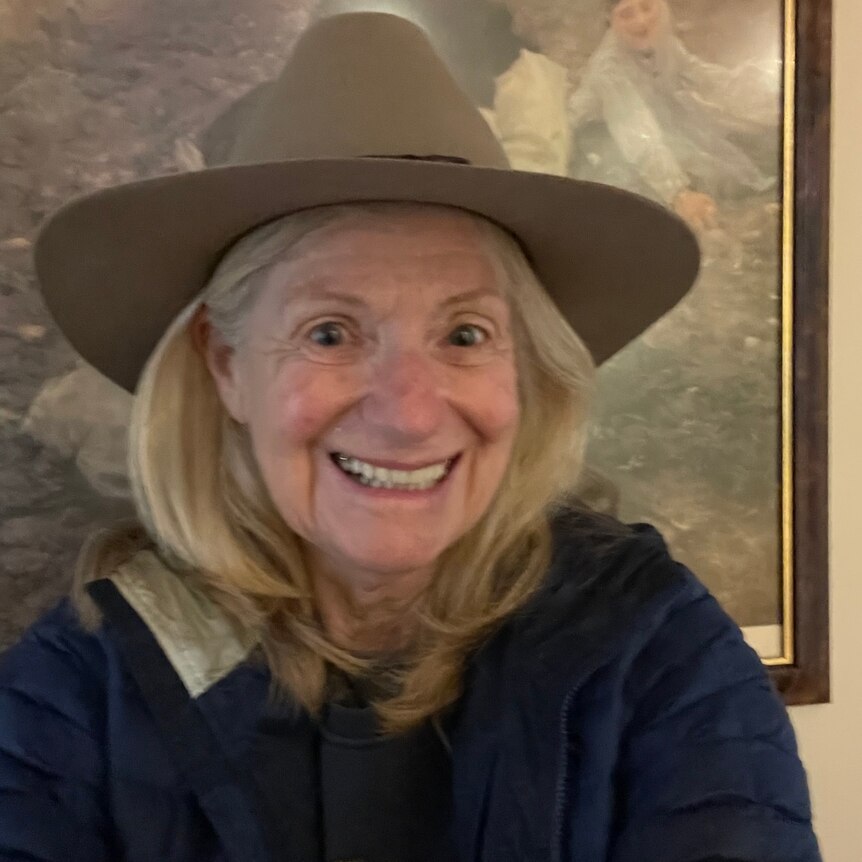 A profile image of a woman with shoulder-length blonde hair, wearing an Akubra hat.