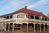 The exterior of a hotel with signs reading 'free australia, and anti vaccination messages