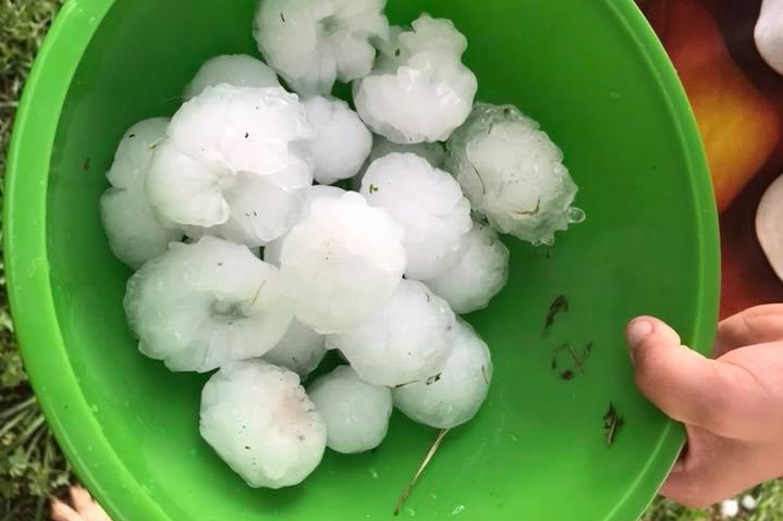 Hail in a green bucket following a thunderstorm