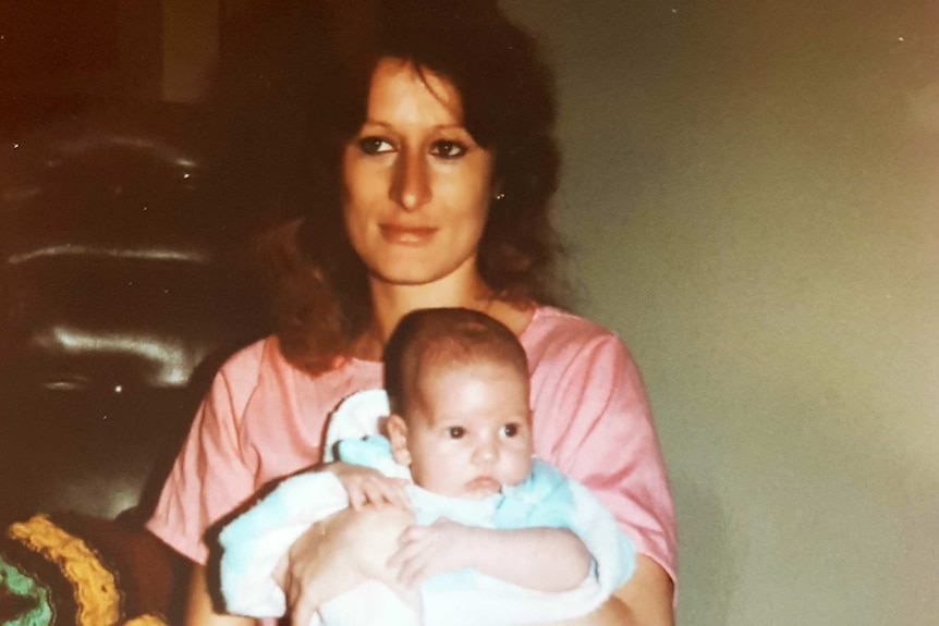 A mother sits with her baby son on her lap