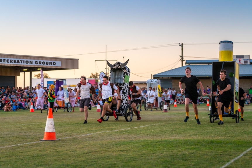 Groups of people racing portable toilets 