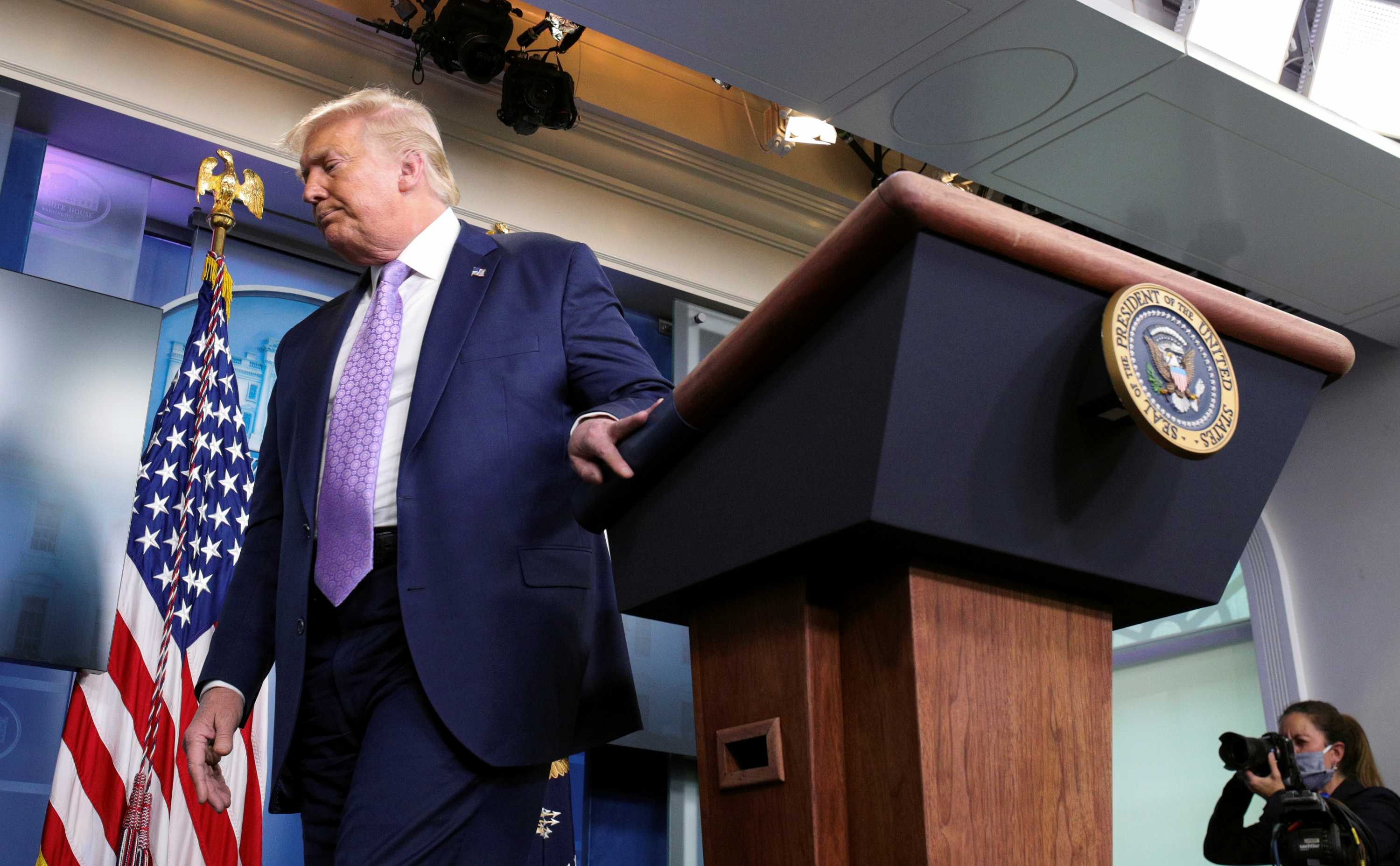 Donald Trump looks away as he leaves the podium at the White House press briefing room