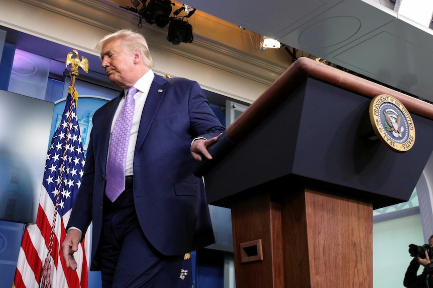 Donald Trump looks away as he leaves the podium at the White House press briefing room