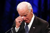Joe Biden wipes a tear away while giving a tribute.