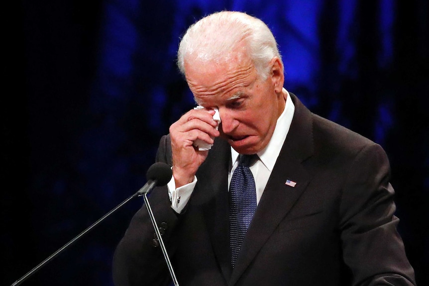 Joe Biden wipes a tear away while giving a tribute.