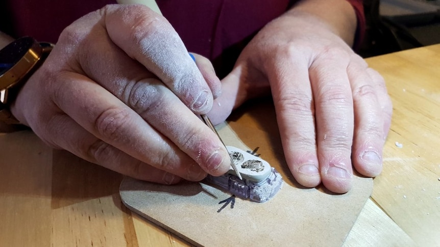 A close up of Ali Murphy's hands as she builds the attachment for her phone required for looping.