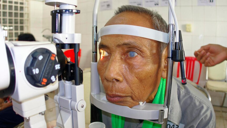 A Cambodian man with cataracts is given an eye test