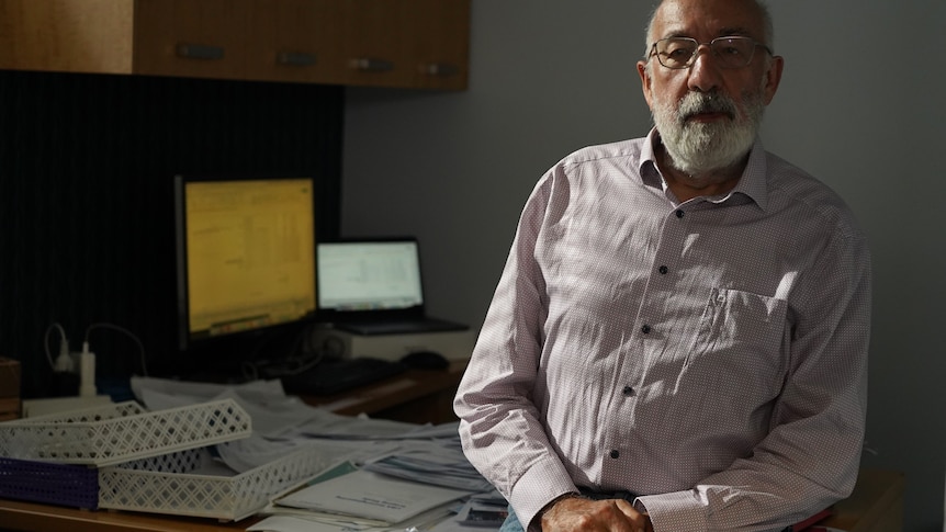 Climate scientist Bill Hare sits on his desk in Fremantle