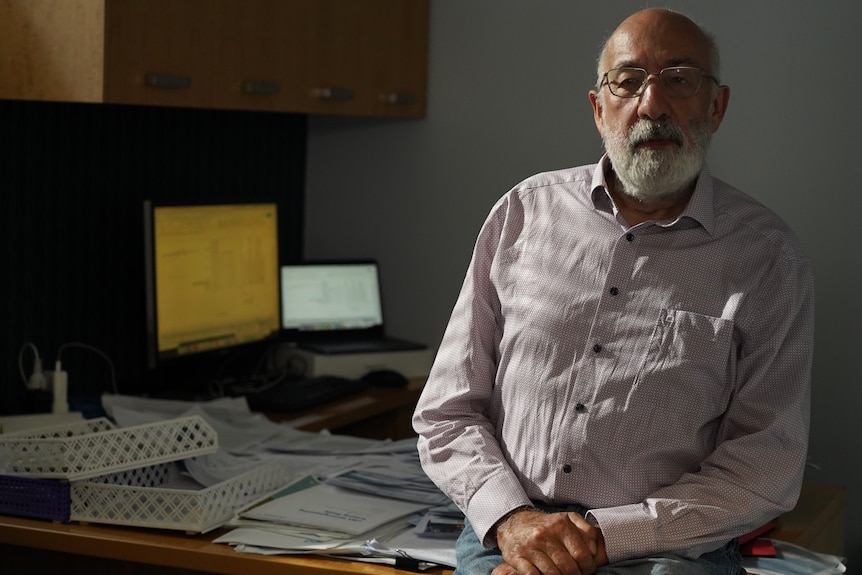 Climate scientist Bill Hare sits on his desk in Fremantle