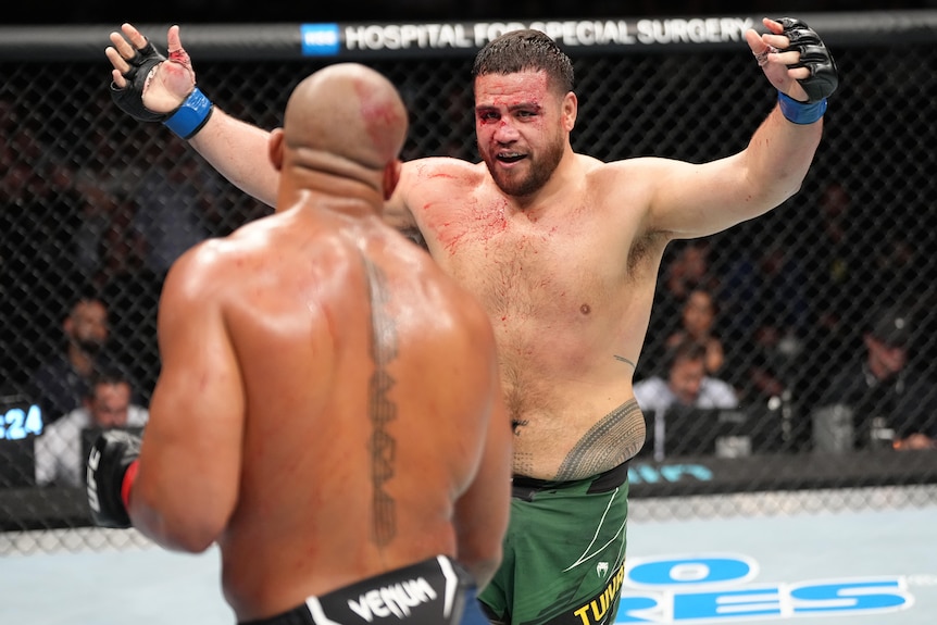 Tai Tuivasa throws his arms in the air during his UFC fight with Cyril Gane.