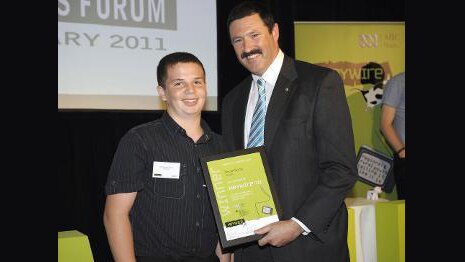 Teenage boy smiles as he is presented with an award