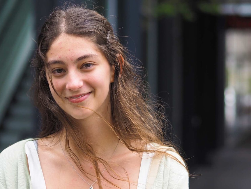 A young woman smiles in a city street