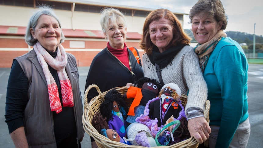 Four women show dolls made by Cygnet Primary School students