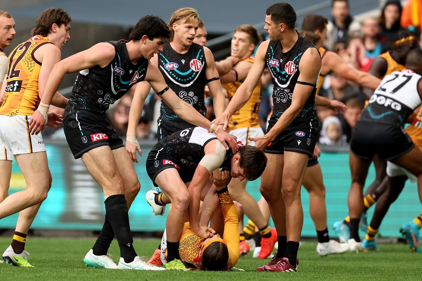 Zak Butters and Jack Ginnivan clash during a 2024 AFL match at Adelaide Oval.