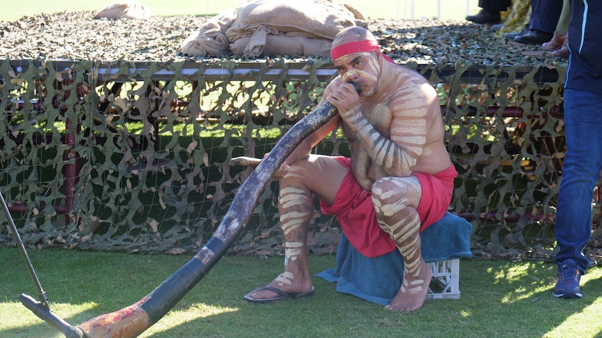 An Aboriginal man playing didgeridoo