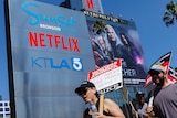 People with picket signs march outside the netflix headquarters 