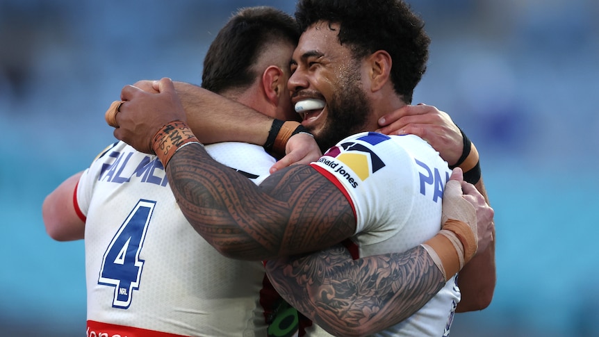 Two men embrace after scoring a try in a rugby league match