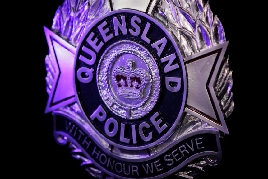 Close-up of Queensland Police Service badge.