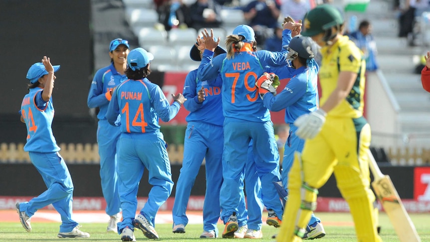 Nicole Bolton, in the foreground, walks past the Indian team celebrating.