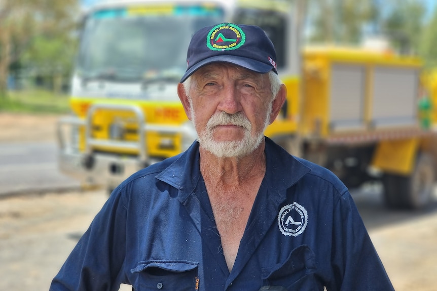 Man with serious face stands in front of fire truck