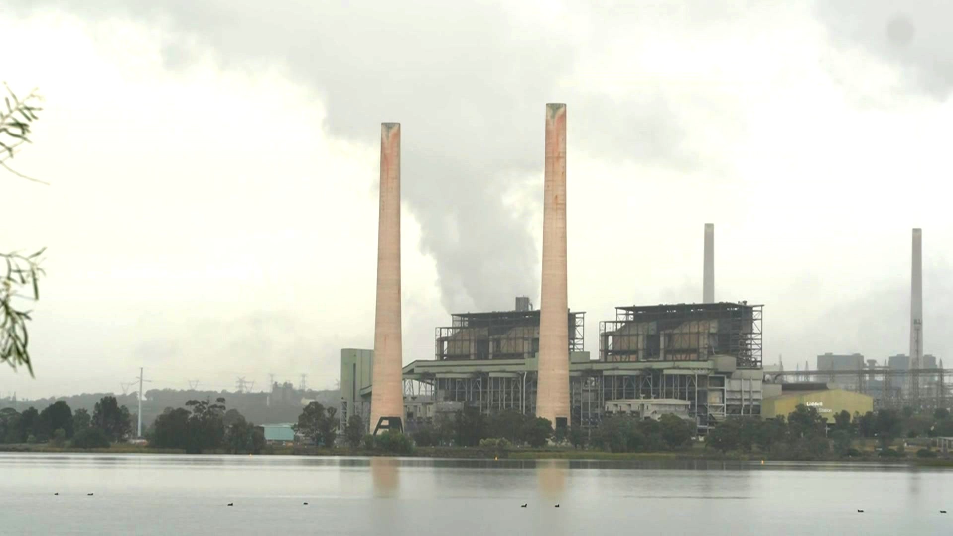 A coal-fired power station as seen from across a waterway.