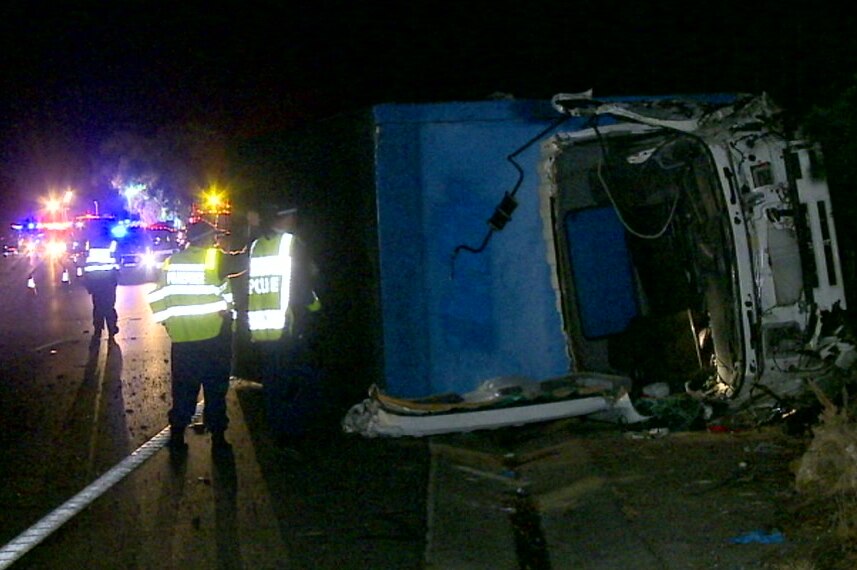 truck wreckage surrounded by emergency services