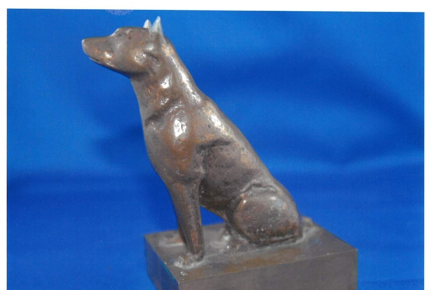 Bronze model of Dog on the Tuckerbox on a vivid blue background