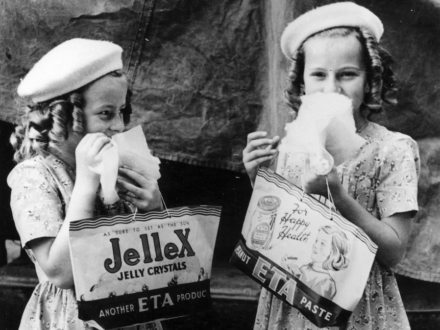 Black and white photo of two young girls holding showbags.